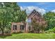 Beautiful brick home with a well-manicured lawn and mature trees at 6723 Joliette Ln, Charlotte, NC 28277