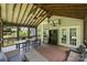 Relaxing screened porch with wood ceiling, fan, dining table and chairs, as well as comfortable couches and furniture at 6723 Joliette Ln, Charlotte, NC 28277