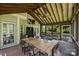 Relaxing screened-in porch complete with an outdoor dining table, TV, stylish seating, and serene backyard views at 6723 Joliette Ln, Charlotte, NC 28277