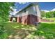 Exterior view of a home with a brick foundation, grassy backyard, and a charming back deck at 735 Shuttles Way, Fort Mill, SC 29715