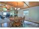 Open-concept dining area with adjacent living room, stone fireplace, and wood paneled ceiling, inviting gathering at 7942 Vista View Dr, Sherrills Ford, NC 28673