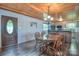 Cozy dining area with wood paneled ceiling, laminate floors, and adjacent kitchen and front door at 7942 Vista View Dr, Sherrills Ford, NC 28673