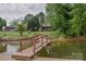 Dock overlooking waterfront home with lush green lawn and surrounding trees, offering a peaceful retreat at 7942 Vista View Dr, Sherrills Ford, NC 28673
