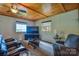 Comfortable living room with wood paneled ceiling, plush seating, and lake views from the window at 7942 Vista View Dr, Sherrills Ford, NC 28673