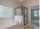 Luxurious bathroom featuring a soaking tub, glass-enclosed shower, and natural light at 968 Autumn Glen Ct, Clover, SC 29710