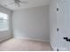 This bedroom has neutral walls, carpet, a window, a fan, and a door with black hardware at 968 Autumn Glen Ct, Clover, SC 29710