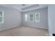 Carpeted main bedroom boasting tray ceilings and large windows that allow natural light into the room at 968 Autumn Glen Ct, Clover, SC 29710