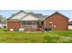 View of the house's brick exterior, screened porch, well-manicured lawn, and cozy outdoor space at 102 Sussex Ave, Cherryville, NC 28021