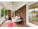 Relaxing screened porch with brick walls, ceiling fan, and comfortable swing at 102 Sussex Ave, Cherryville, NC 28021