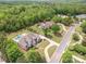 Gorgeous aerial view of the home nestled among lush trees, a private pool, and a tennis court at 1045 Spyglass Ln, Waxhaw, NC 28173