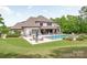 An incredible outdoor living space with a beautiful pool, patio, lounge chairs, and manicured lawn at 1045 Spyglass Ln, Waxhaw, NC 28173