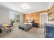 Cozy bedroom featuring a wood-paneled wall, desk area, and abundant natural light at 1045 Spyglass Ln, Waxhaw, NC 28173