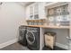 Modern laundry room features a countertop, decorative backsplash, and front-loading washer and dryer at 1045 Spyglass Ln, Waxhaw, NC 28173