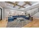 Inviting living room with a blue sectional sofa, gray rug, hardwood floors, and staircase at 1045 Spyglass Ln, Waxhaw, NC 28173