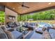 Inviting covered patio featuring brick accents, plush seating, and a view of the sparkling pool at 1045 Spyglass Ln, Waxhaw, NC 28173