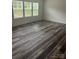 Light filled living room with three windows and new gray wood-look flooring at 113 Stoney Ln, Cherryville, NC 28021