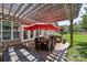 Covered outdoor patio with a dining table, grill, and a red umbrella at 11621 Mount Argus Dr, Cornelius, NC 28031