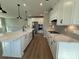 Modern kitchen featuring white cabinets, a large island, stainless steel appliances, and wood-look flooring at 12033 Lavinia Ln, Charlotte, NC 28277