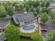 Aerial view of a community pool surrounded by a fence, mature trees, and parking at 13360 Old Compton Ct, Pineville, NC 28134