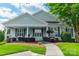 Charming single-story home with a covered front porch and well-manicured landscaping at 13360 Old Compton Ct, Pineville, NC 28134