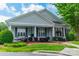 Charming home with a covered front porch, large windows, and a beautifully landscaped yard at 13360 Old Compton Ct, Pineville, NC 28134