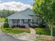 Charming single-story home with a welcoming porch and lush landscaping at 13360 Old Compton Ct, Pineville, NC 28134