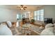 Bright living room featuring hardwood floors, a ceiling fan, and ample natural light at 13360 Old Compton Ct, Pineville, NC 28134