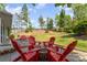 Inviting backyard featuring a fire pit and red Adirondack chairs, perfect for outdoor entertaining at 13406 Ada Ct, Charlotte, NC 28213