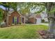 Charming brick two-story home featuring a well-manicured lawn, landscaping, and two car garage at 13406 Ada Ct, Charlotte, NC 28213