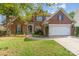 Charming brick two-story home featuring a well-manicured lawn, landscaping, and two car garage at 13406 Ada Ct, Charlotte, NC 28213