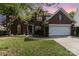 Charming brick two-story home featuring a well-manicured lawn, landscaping, and two car garage at 13406 Ada Ct, Charlotte, NC 28213