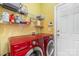 Functional laundry room with red LG washer and dryer and storage shelves for efficient organization and chores at 13406 Ada Ct, Charlotte, NC 28213