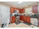 Well-lit kitchen features stainless steel appliances, tile flooring, and dark wood cabinetry at 1346 Mandy Place Ct, Charlotte, NC 28216