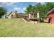 Large backyard with a covered patio and an outbuilding featuring a brick exterior at 14834 Pawnee Trl, Matthews, NC 28104