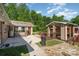Landscaped backyard with a covered patio, brick outbuilding and an additional storage shed at 14834 Pawnee Trl, Matthews, NC 28104