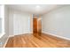 Bedroom featuring hardwood floors, a closet, neutral paint, and a wood door at 14834 Pawnee Trl, Matthews, NC 28104