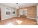 Open dining room showcasing brick accent wall, wood flooring, modern light fixture, and large windows at 14834 Pawnee Trl, Matthews, NC 28104