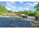 Long driveway to charming brick home, surrounded by lush greenery, with black fencing and an outbuilding at 14834 Pawnee Trl, Matthews, NC 28104