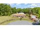 Beautifully landscaped brick ranch home with manicured lawn, circular drive, and a backdrop of mature trees at 14834 Pawnee Trl, Matthews, NC 28104