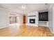 Bright living room featuring a stone fireplace, wood floors, and sliding glass doors to the outdoor area at 14834 Pawnee Trl, Matthews, NC 28104
