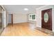 Light-filled living room featuring hardwood floors, a front door with decorative glass, and large windows at 14834 Pawnee Trl, Matthews, NC 28104