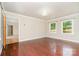 Bright living room with beautiful hardwood floors, two windows, and white trim throughout at 14834 Pawnee Trl, Matthews, NC 28104