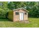 Brick outbuilding in the backyard with a simple white door and small windows at 14834 Pawnee Trl, Matthews, NC 28104