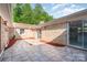 Tiled patio with brick walls, sliding doors, and landscaping for an inviting outdoor living space at 14834 Pawnee Trl, Matthews, NC 28104