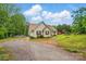 Charming single-story home featuring a gravel driveway, a vibrant yard, and red shutter accents at 1534 Buffalo Shoals Rd, Lincolnton, NC 28092