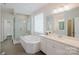 Bright bathroom featuring a soaking tub, walk-in shower, and double vanity with white cabinets at 15431 Cimarron Hills Ln, Charlotte, NC 28278