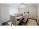 Formal dining room features modern chandelier, neutral decor, and hardwood floors at 15431 Cimarron Hills Ln, Charlotte, NC 28278