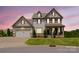 Traditional two-story home featuring a welcoming front porch, attached garage, and manicured lawn at 15431 Cimarron Hills Ln, Charlotte, NC 28278