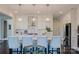The kitchen island features pendant lighting, a stainless steel range hood, and white cabinets at 15431 Cimarron Hills Ln, Charlotte, NC 28278