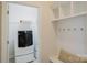 Convenient mudroom with coat hooks, shelving, and bench seating near the laundry appliances at 15431 Cimarron Hills Ln, Charlotte, NC 28278